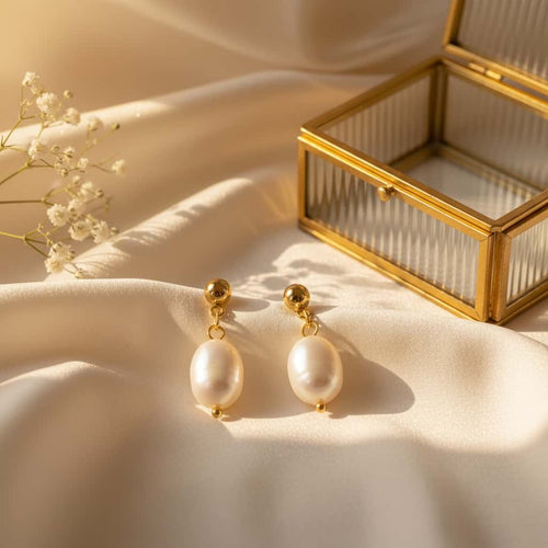 Baroque pearl drop σκουλαρίκια, χρυσό ανοξείδωτο ατσάλι με freshwater pearl, flat lay σε σατέν με glass jewelry box — Celestial Steel