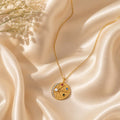 Celestial coin pendant κολιέ, χρυσό ανοξείδωτο ατσάλι με multicolor ζιρκόν και star burst, flat lay σε σατέν — Celestial Steel