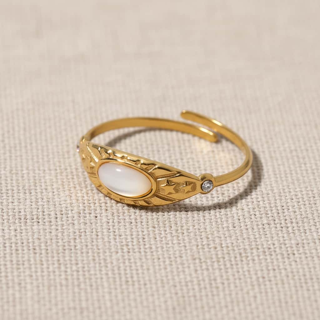 Celestial opal cuff δαχτυλίδι, χρυσό ανοξείδωτο ατσάλι με λευκή opal και star engravings, flat lay σε linen — Celestial Steel