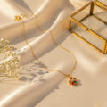 Κολιέ με περιστρεφόμενο flower pendant πολύχρωμα ζιργκόν, χρυσό ανοξείδωτο ατσάλι, lifestyle σε σατέν — Celestial Steel