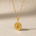 Compass rose coin pendant κολιέ, χρυσό ανοξείδωτο ατσάλι με μαύρο ζιρκόν και filigree engraving, flat lay σε linen — Celestial Steel