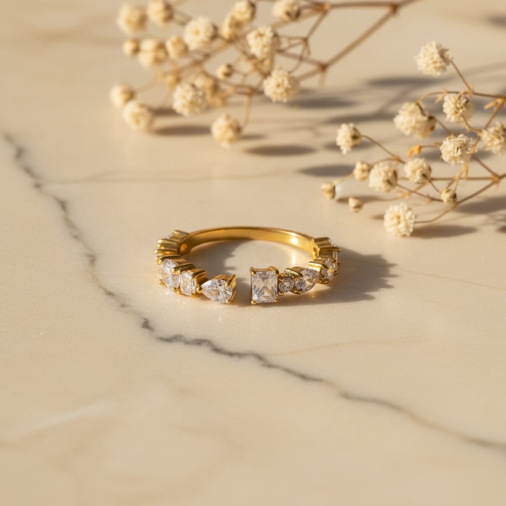 Δαχτυλίδι open band με cushion-cut και pear-cut ζιργκόν, χρυσό ανοξείδωτο ατσάλι, flat lay σε μάρμαρο — Celestial Steel