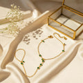 Emerald ζιρκόν hand chain βραχιόλι, χρυσό ανοξείδωτο ατσάλι με πράσινο ζιρκόν, flat lay σε σατέν με glass jewelry box — Celestial Steel