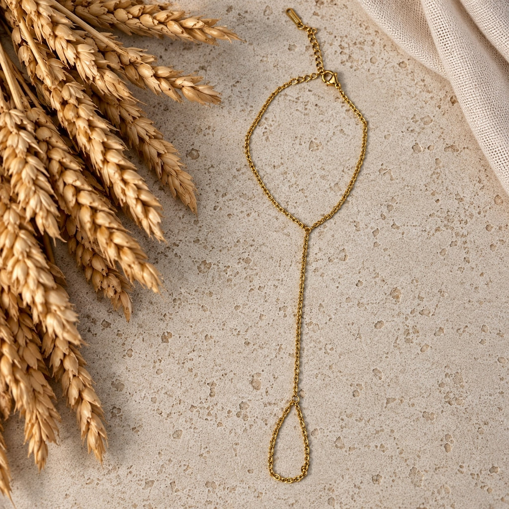 Επιχρυσωμένο hand chain σε travertine επιφάνεια — Celestial Steel