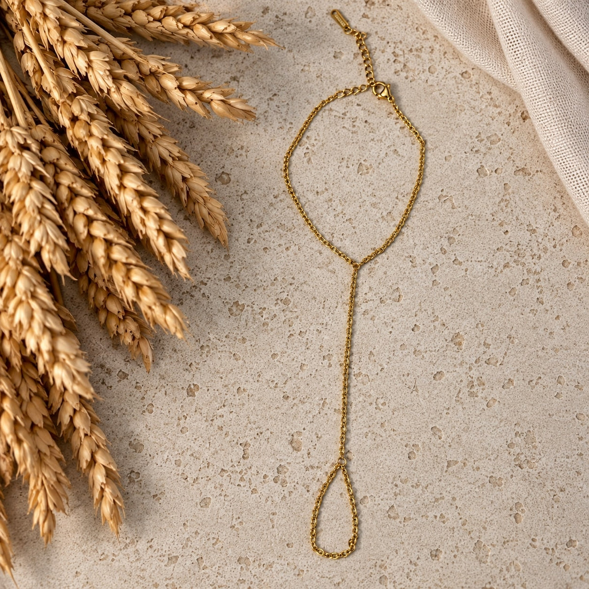 Επιχρυσωμένο hand chain σε travertine επιφάνεια — Celestial Steel