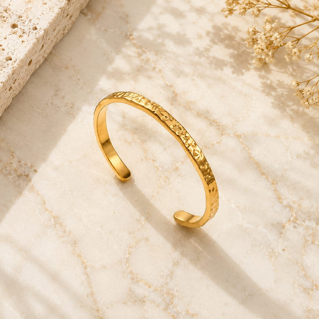 Hammered open cuff bangle βραχιόλι, χρυσό ανοξείδωτο ατσάλι, flat lay σε μάρμαρο — Celestial Steel