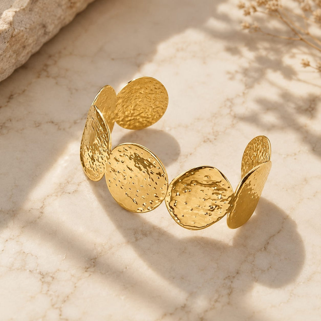Βραχιόλι cuff με hammered oval discs, χρυσό ανοξείδωτο ατσάλι, product shot σε μάρμαρο — Celestial Steel 