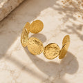 Βραχιόλι cuff με hammered oval discs, χρυσό ανοξείδωτο ατσάλι, product shot σε μάρμαρο — Celestial Steel 