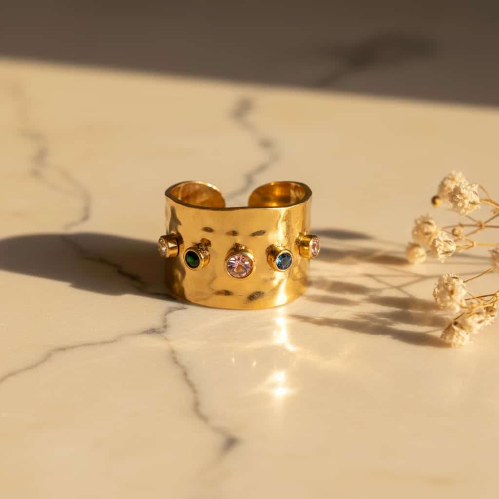 Hammered multicolor cuff δαχτυλίδι, χρυσό ανοξείδωτο ατσάλι με 5 multicolor ζιρκόν, close-up σε μάρμαρο — Celestial Steel