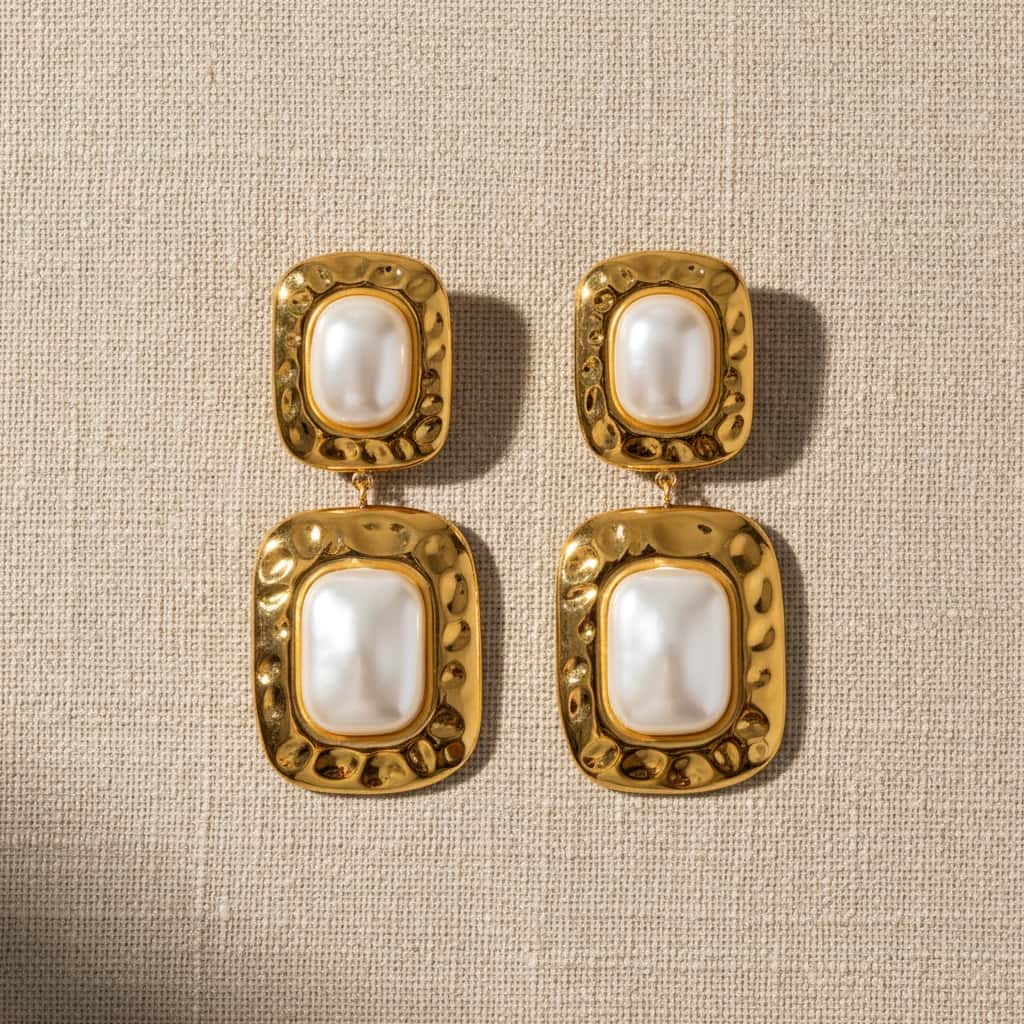 Σκουλαρίκια drop με διπλό hammered τετράγωνο και freshwater pearl, χρυσό ανοξείδωτο ατσάλι, flat lay σε linen — Celestial Steel
