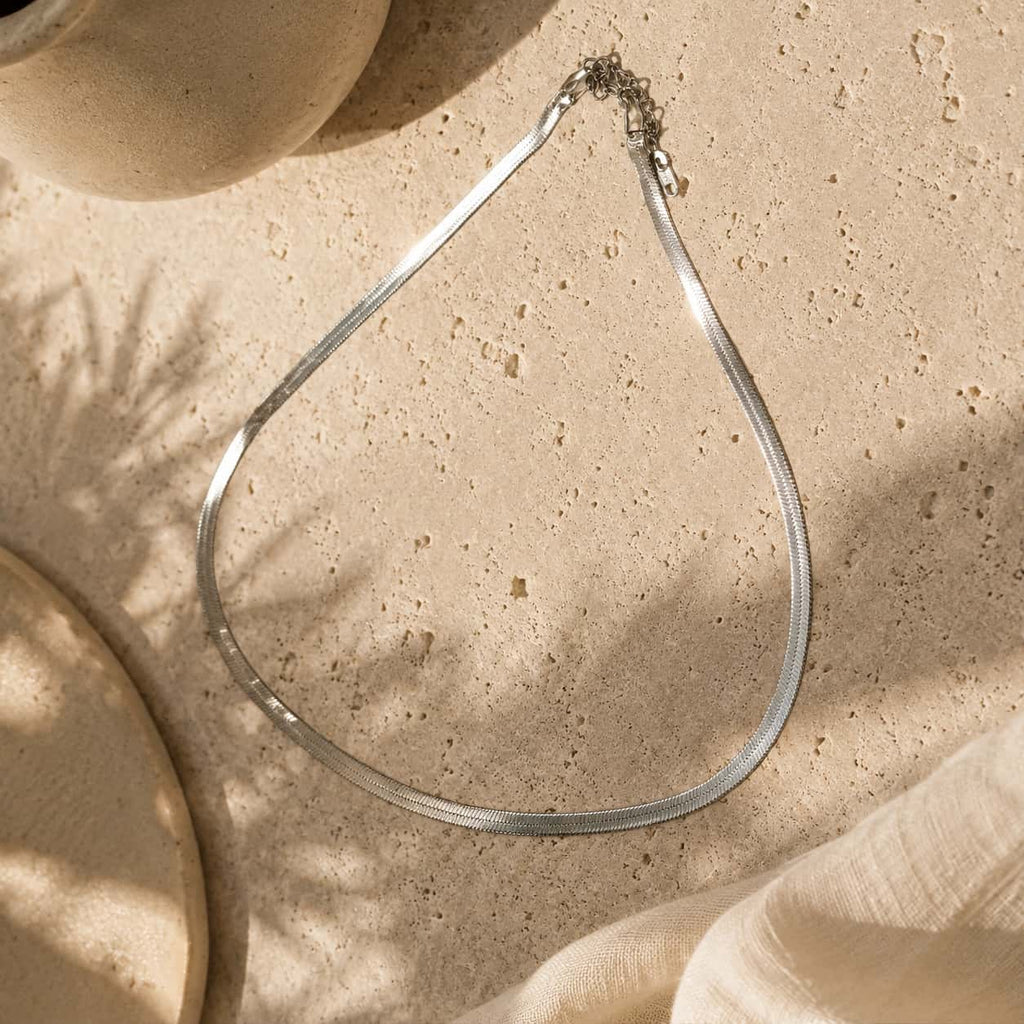 Ασιμί κολιέ snake chain σε marble επιφάνεια — Celestial Steel