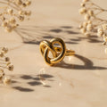Δαχτυλίδι sculptural knot, χρυσό ανοξείδωτο ατσάλι, flat lay σε μάρμαρο με gypsophila — Celestial Steel