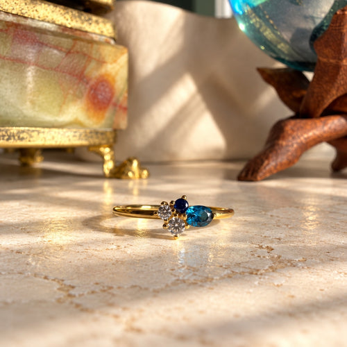 London blue topaz και sapphire cluster δαχτυλίδι, χρυσό 925 ασήμι χειροποίητο, flat lay σε μάρμαρο — Celestial Steel