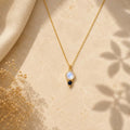 Moonstone και sapphire pendant κολιέ, χρυσό 925 ασήμι χειροποίητο, flat lay σε μάρμαρο — Celestial Steel