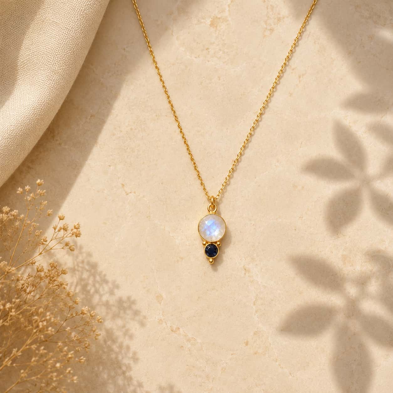 Moonstone και sapphire pendant κολιέ, χρυσό 925 ασήμι χειροποίητο, flat lay σε μάρμαρο — Celestial Steel