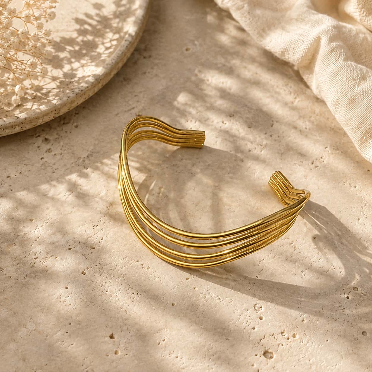 Χρυσό τετραπλό cuff βραχιόλι σε marble editorial σύνθεση — Celestial Steel
