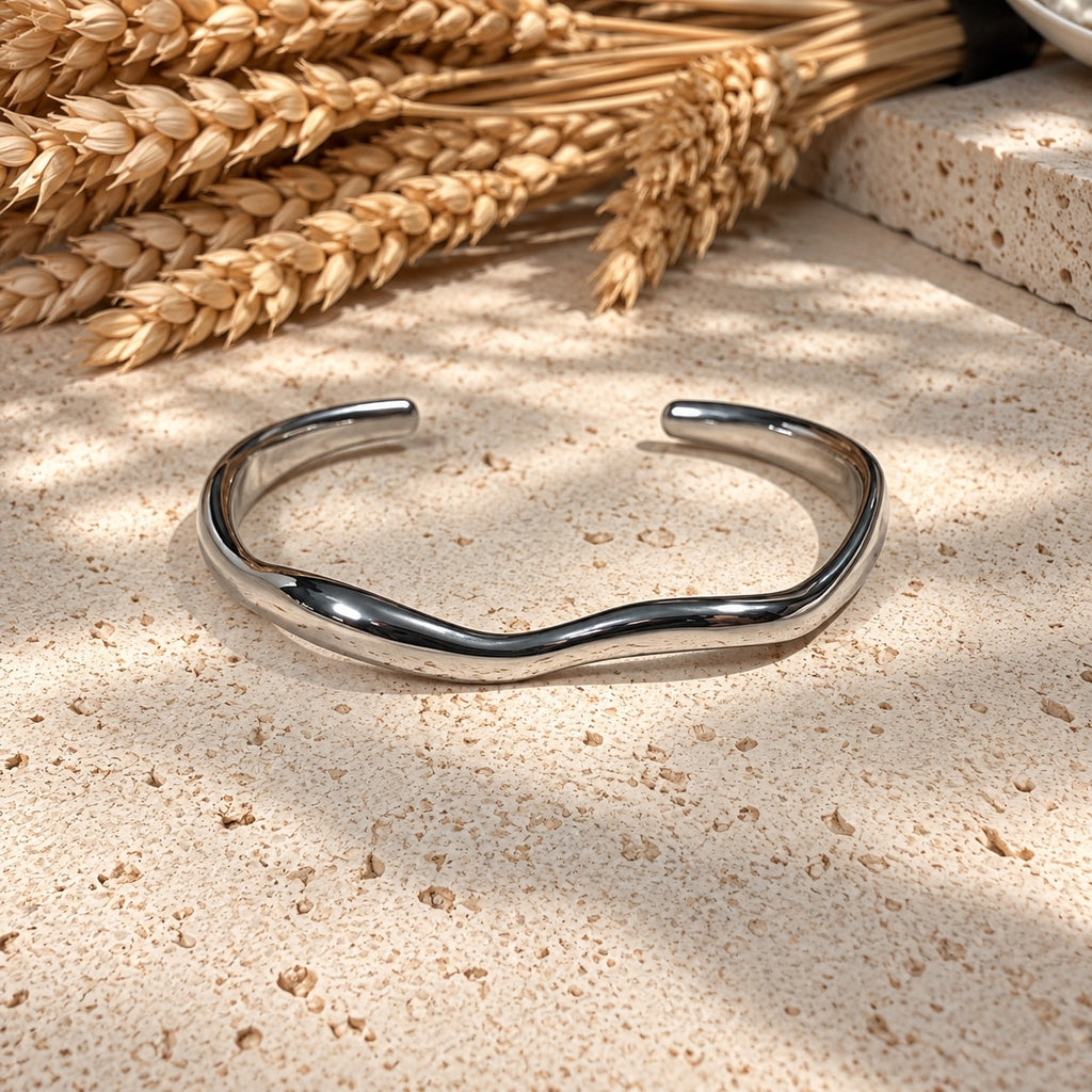 Ασημένια open cuff με wave σχεδιασμό σε λευκό αντικείμενο — Celestial Steel