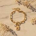 Βραχιόλι paperclip chain με engraved charm και ζιργκόν σε χρυσό ανοξείδωτο ατσάλι, lifestyle με μάρμαρο και gypsophila — Celestial Steel