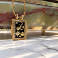Χρυσό μενταγιόν με πλανήτες, σελήνη, αστέρια και ζιργκόν πάνω σε μαύρο σμάλτο — Celestial Steel