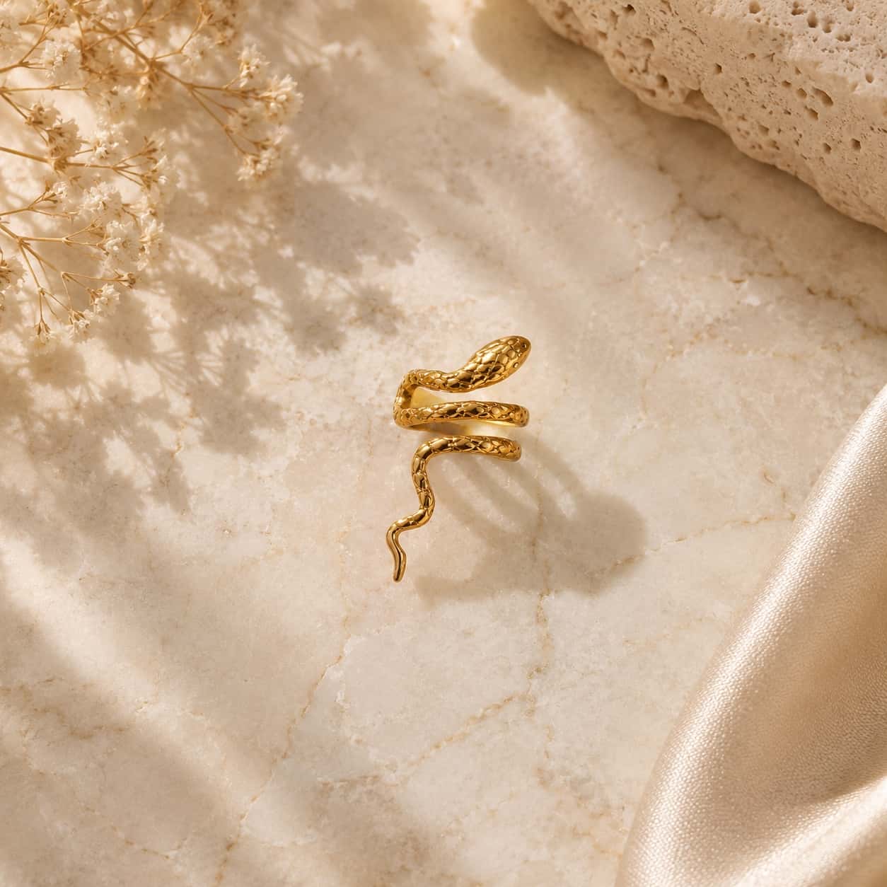 Snake ear cuff σκουλαρίκι, χρυσό ανοξείδωτο ατσάλι, flat lay σε μάρμαρο — Celestial Steel