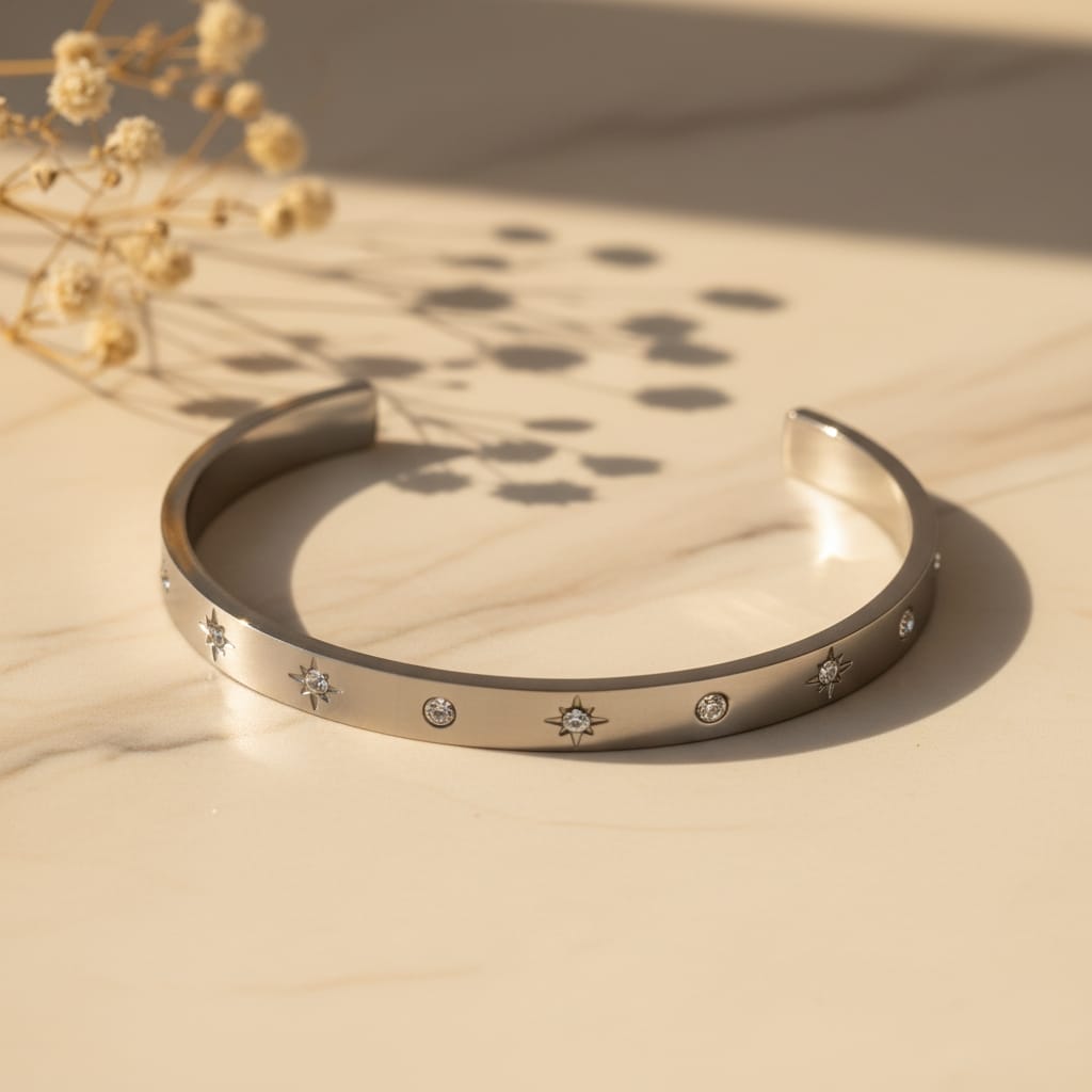 Star zircon open cuff bangle βραχιόλι, ασημί ανοξείδωτο ατσάλι με star burst και round ζιργκόν, flat lay σε μάρμαρο — Celestial Steel