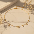 Κολιέ με starburst pave ζιργκόν και bezel-set ζιργκόν charms, χρυσό ανοξείδωτο ατσάλι, flat lay σε μάρμαρο — Celestial Steel