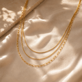 Layered 3-in-1 κολιέ snake, twisted rope και paperclip chain, χρυσό ανοξείδωτο ατσάλι, flat lay σε σατέν — Celestial Steel