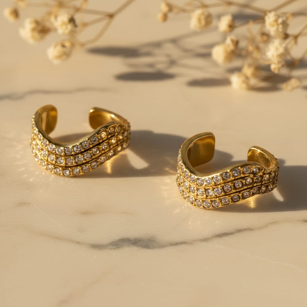 Κοντινό ear cuffs τριπλή σειρά pave ζιργκόν, χρυσό ανοξείδωτο ατσάλι, flat lay σε μάρμαρο — Celestial Steel