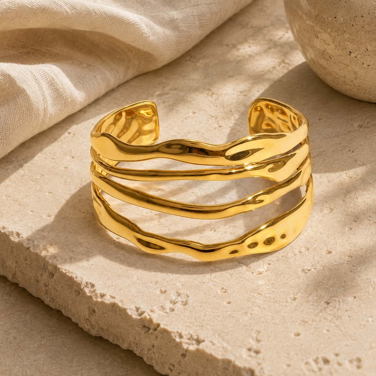 Χρυσό τετραπλό κυματιστό cuff σε marble επιφάνεια — Celestial Steel