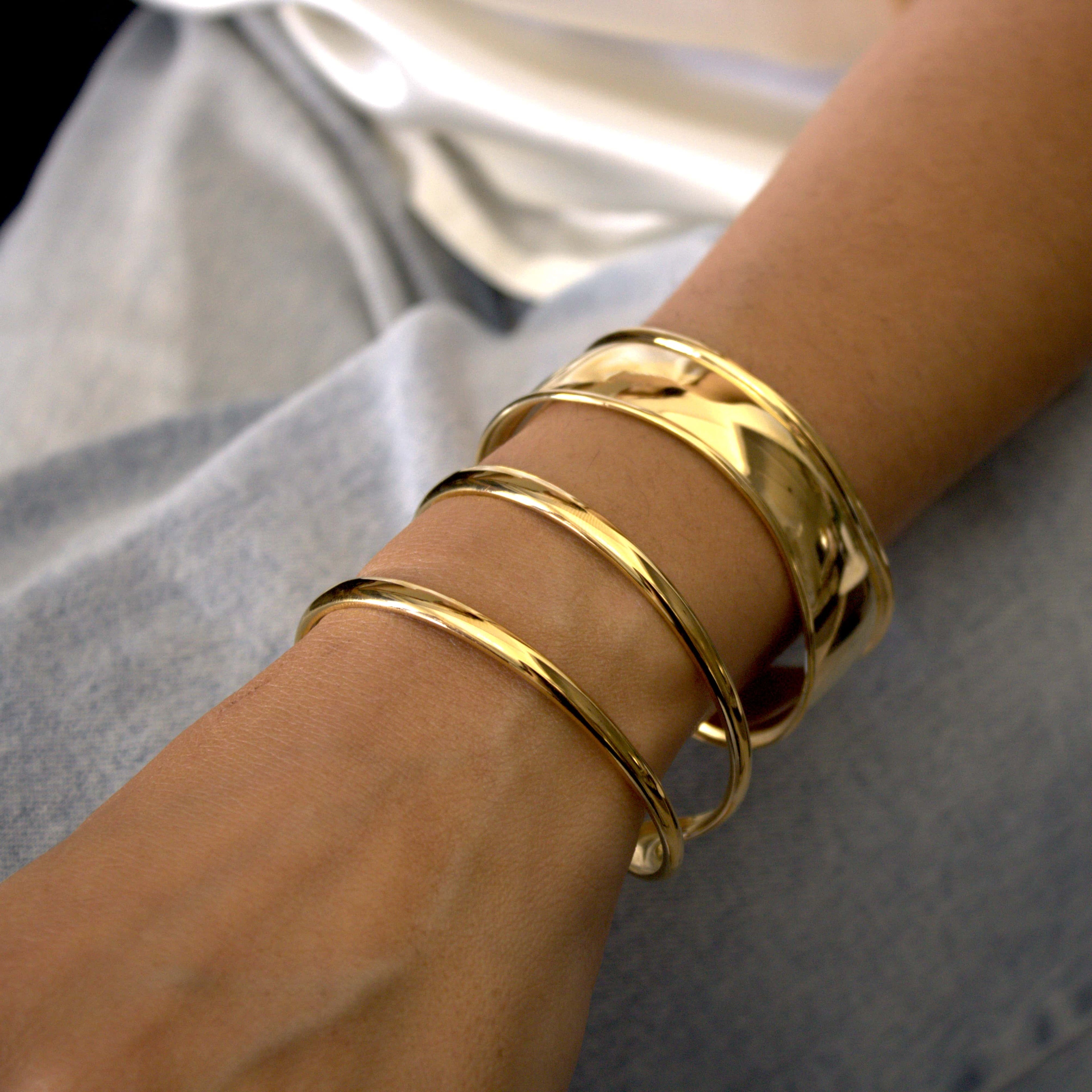 Wide open cuff βραχιόλι με wavy profile σε high polish χρυσό ανοξείδωτο ατσάλι φορεμένο — Celestial Steel